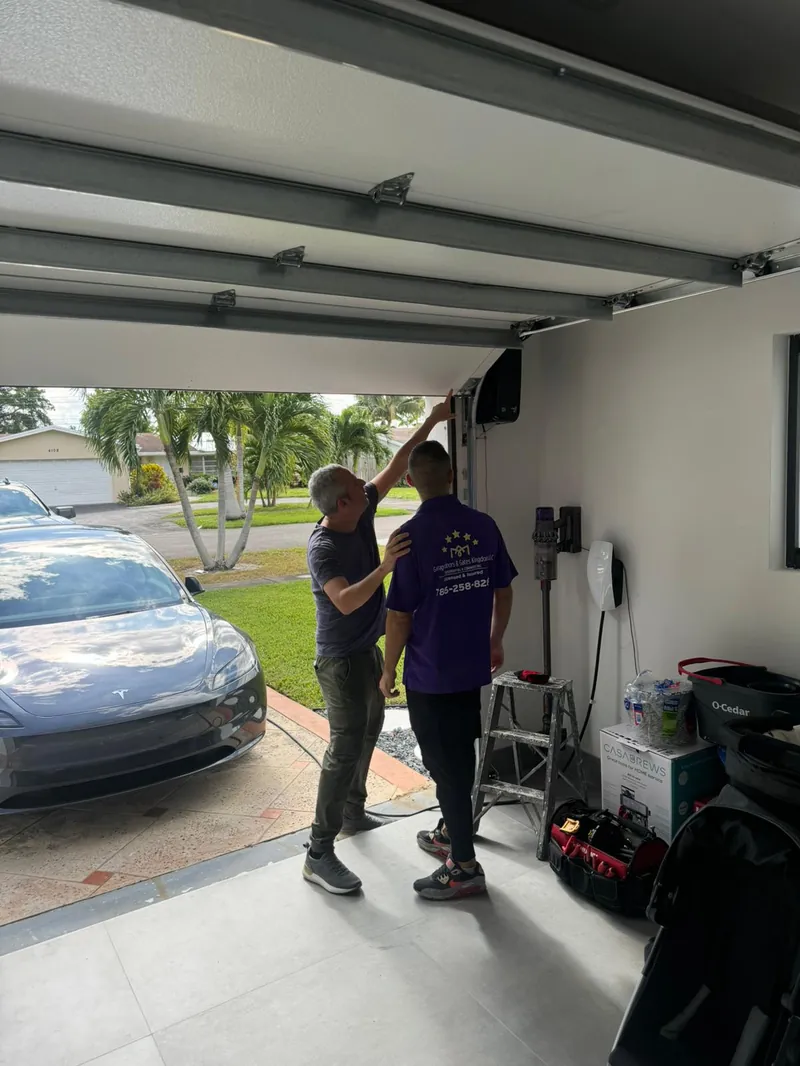 Yarin Ifergan with a Garage Door Kingdom technician inspecting a newly installed LiftMaster myQ Wi-Fi garage door opener at a Sunrise, FL home